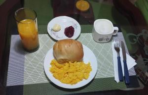a table with a plate of scrambled eggs and a drink at Hogar Emerawa - Corferias Bogota - Embajada Americana in Bogotá