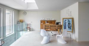 una camera con una scrivania e due sedie bianche di ALKIMIA boutique hotel a Vasto