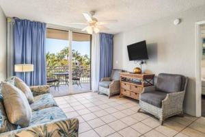 ein Wohnzimmer mit einem Sofa, Stühlen und einem TV in der Unterkunft NEW Grenada Suite - Parking Pool & Pets 209 in Key West