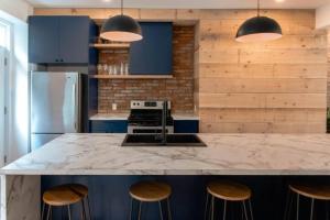 ケベック・シティーにあるThe Old New // Spacious 2000 sqft condo - Downtownのキッチン(大理石のカウンタートップ、青いキャビネット付)