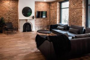 ケベック・シティーにあるThe Old New // Spacious 2000 sqft condo - Downtownのソファと暖炉のあるリビングルーム