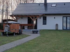 ein weißes Haus mit einem Dach und einem Grill in der Unterkunft SielAnka Domek letniskowy całoroczny in Orchowo