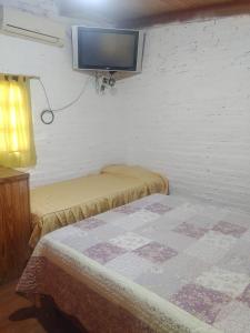 a room with two beds and a tv on the wall at RINCON SOÑADO in Paso de la Patria