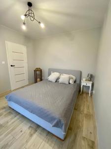 Orchowo的住宿－SielAnka Domek letniskowy całoroczny，一间卧室配有一张带蓝色棉被的床