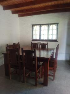 a wooden table and chairs in a room with a window at RINCON SOÑADO in Paso de la Patria