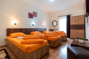 クルジュ・ナポカにあるPensiunea Diadisのオレンジ色の枕が備わるベッド1台