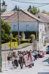 grupa ludzi idących ulicą w obiekcie Valverde Santar Hotel & SPA w mieście Santar