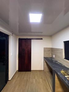 ein leeres Zimmer mit einer Tür und einem Holztisch in der Unterkunft Container Home Py in Puerto Presidente Franco