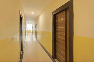 a hallway with a wooden door in a building at Hotel Saharsh Grand Near Shilparamam in Hyderabad
