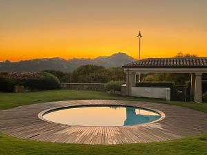 a pool in a yard with a sunset in the background at Gardenia Luxury in Palau