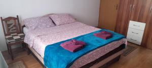 a bedroom with a bed with two purple pillows at Aura City 2 in Visoko
