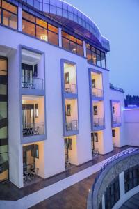 een groot wit gebouw met ramen en een balkon bij Standard Single Room At Amikus Hotel in Gasanze