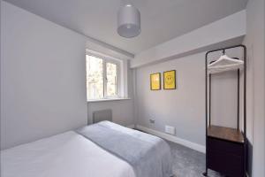 ジェドバラにあるApartment in Scottish Bordersのベッドと鏡のある白い寝室