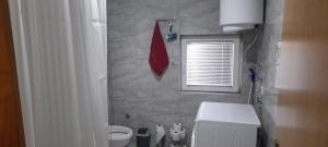 a bathroom with a white toilet and a window at Aura City 2 in Visoko +9 photos