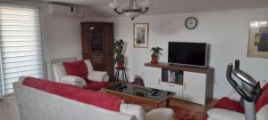 a living room with a couch and a tv at Aura City 2 in Visoko