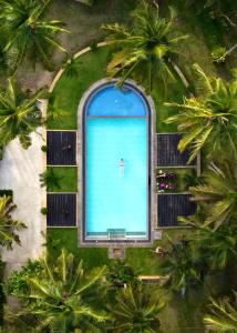 une personne debout au milieu d'une grande piscine dans l'établissement Hotel Riverrina, à Negombo