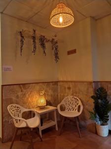 a room with two chairs and a table and a chandelier at Hostal La Cigueña in El Espinar