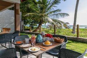 a table with food on a patio with a view of the ocean at Costa Dourada Village in Maragogi