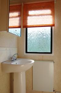 bagno con lavandino e finestra di Caravan 252 Bryn Y Mor Beach Side Park a Tywyn