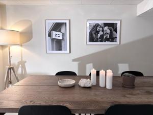 a dining room with a wooden table with candles on it at Nomad Gardet in Stockholm
