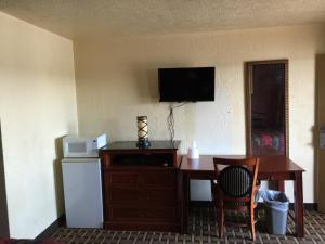 a room with a desk with a microwave and a refrigerator at Encore Motel in Farmington