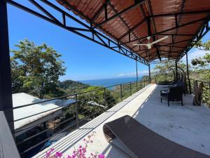einen Balkon eines Hauses mit Meerblick in der Unterkunft Blue View by Ronny’s Place in Quepos