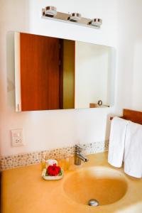 a bathroom sink with a large mirror above it at Villas San Sebastian in Zihuatanejo