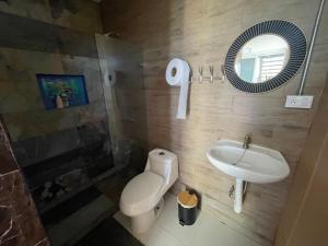 ein Badezimmer mit einem WC, einem Waschbecken und einem Spiegel in der Unterkunft Blue View by Ronny’s Place in Quepos