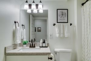 a white bathroom with a sink and a mirror at Modern Studio Oasis, WFH, Mins to Uni of Portland in Portland