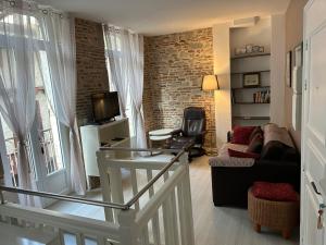 a living room with a staircase leading to a living room at Coeur de Bastide in Villeneuve-sur-Lot