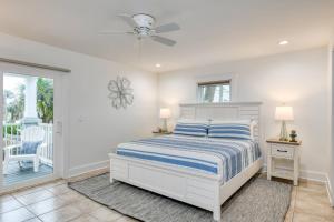 um quarto branco com uma cama e uma ventoinha em Maritime Place em Saint Augustine