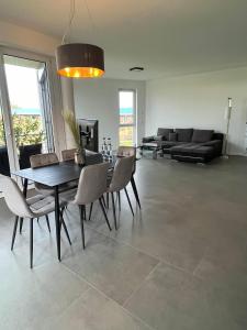 a dining room with a table and chairs and a couch at Luxus Neubauwohnung mit Blick auf den Phönix-See in Dortmund