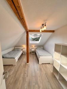 a attic room with two beds and a window at Mc Monti Gießen - Lich, 70qm, Zentral, NETFLIX in Lich