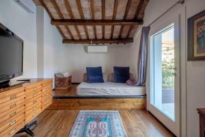 a bedroom with a bed with blue pillows and a tv at La Casetta nel Cerchio in Ravenna