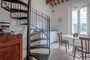 a spiral staircase in a living room with a table at La Casetta nel Cerchio in Ravenna