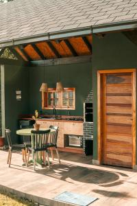 a kitchen with a table and chairs and a wooden door at Casa bolha in Imaruí