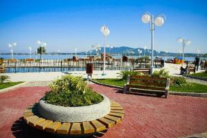 een park met een bank en uitzicht op het water bij Pousada Beira Mar Centro São Pedro da Aldeia Rio de Janeiro in São Pedro da Aldeia