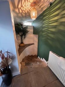 a hallway with a green wall and a potted plant at Ty Daisy, Gilwern in Gilwern