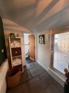 a room with a bathroom with a window and a shelf with towels at Ty Daisy, Gilwern in Gilwern