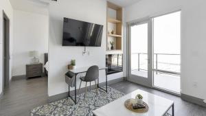 sala de estar con escritorio y TV en la pared en Landing Modern Apartment with Amazing Amenities (ID1381X635), en The Colony