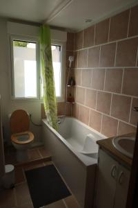 La salle de bains est pourvue d'une baignoire, de toilettes et d'un lavabo. dans l'établissement Maison d'architecte avec vue sur Sens, à Paron