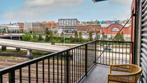 a balcony with a chair and a view of a city at Landing Modern Apartment with Amazing Amenities (ID8493X21) in Tacoma