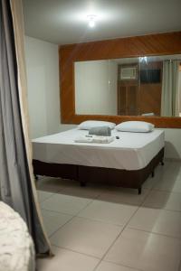 sypialnia z dużym łóżkiem z lustrem w obiekcie HOTEL VILAS DOS MONTES w mieście Montes Claros