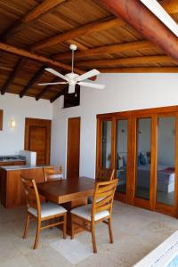 a dining room with a table and a ceiling fan at Villas San Sebastian in Zihuatanejo