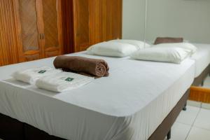 dwa białe łóżka z ręcznikami na górze w obiekcie HOTEL VILAS DOS MONTES w mieście Montes Claros