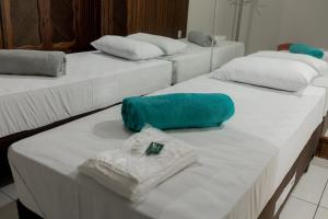 un grupo de tres camas con toallas. en HOTEL VILAS DOS MONTES, en Montes Claros