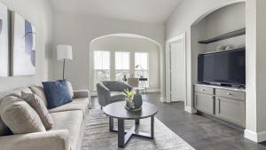 sala de estar con sofá, TV y mesa en Landing Modern Apartment with Amazing Amenities (ID1283X447), en Richmond