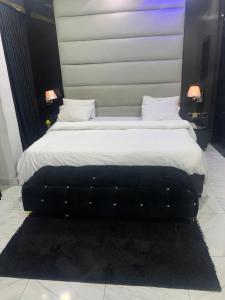 a bedroom with a large bed with a black headboard at GT Guesthouse in Warri