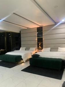 a bedroom with two beds and a green couch at GT Guesthouse in Warri