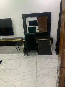 a living room with a desk and a mirror at GT Guesthouse in Warri